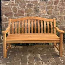 Load image into Gallery viewer, Wooden bench in front of a stone building with 'The Stone House' sign.