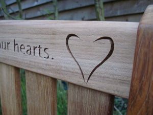 heart carved into wood on memorial bench