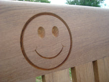 Load image into Gallery viewer, Smiley face logo carved into wood on a memorial bench - 4mb0965