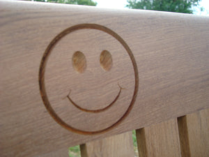 Smiley face logo carved into wood on a memorial bench - 4mb0965