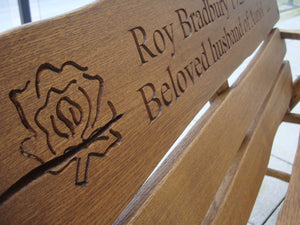 Rustic oak memorial bench with an engraved rose image