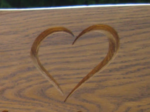 Heart symbol carved into wood on a memorial bench - 4mb2330
