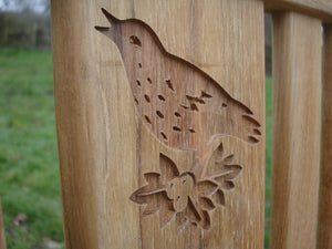 Singing bird on a branch carved into wood on a memorial bench - 4mb1505