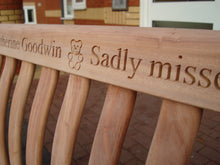 Load image into Gallery viewer, A Teddy bear symbol carved into wood on a memorial bench - 4mb2756