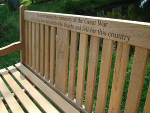 British Legion poppy carved into the wood on a memorial bench - 4mb3099